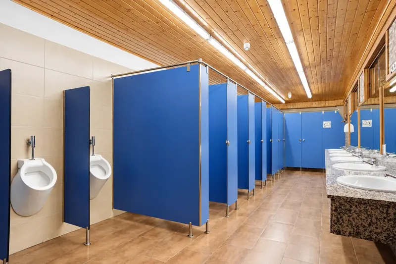 Intérieur des sanitaires de La Mola avec douches chaudes et boiseries